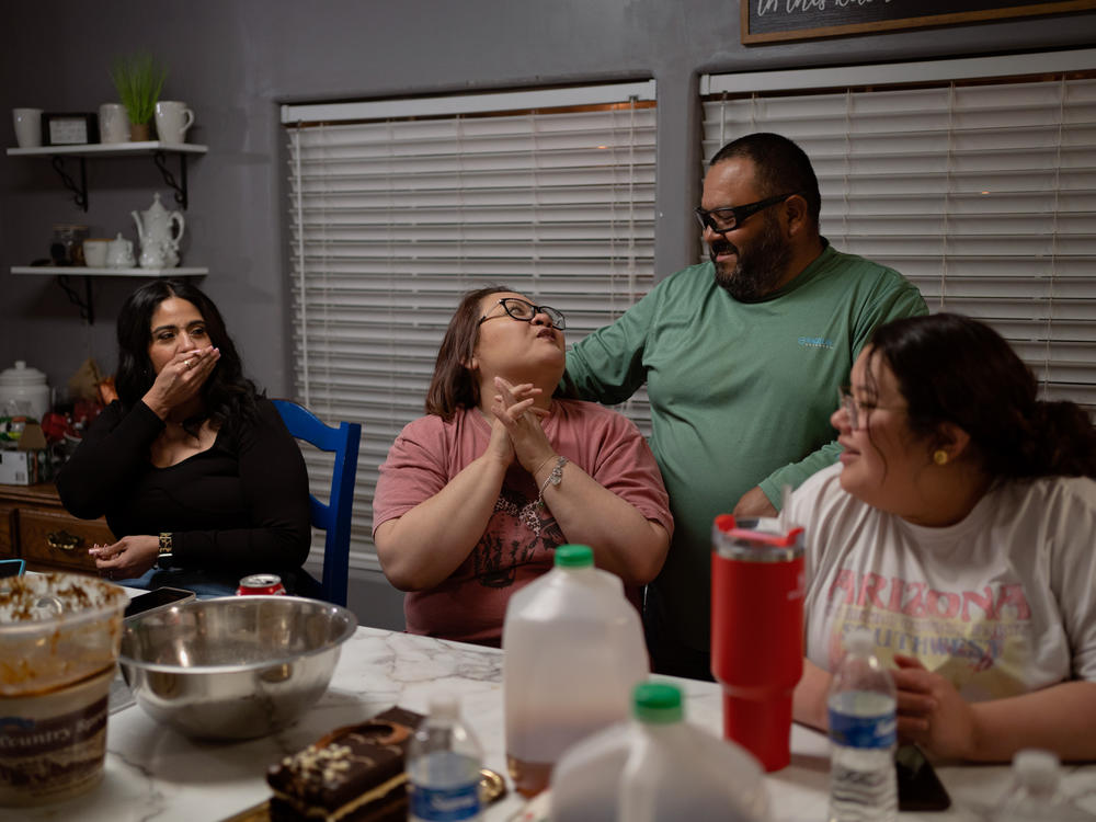 Cindy Almance (center left) and her husband, Eddie (center right), talk as their daughter Caitlynn looks on. Cindy and Eddie have been married for 23 years.