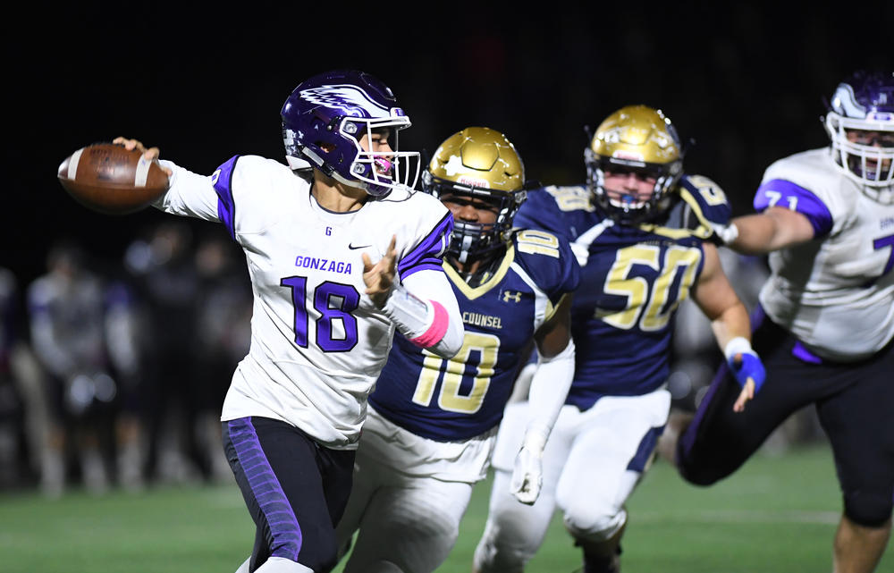 Gonzaga quarterback Caleb Williams (18) rolls out against Good Counsel linebacker Jalen Green (10) during a high school game.