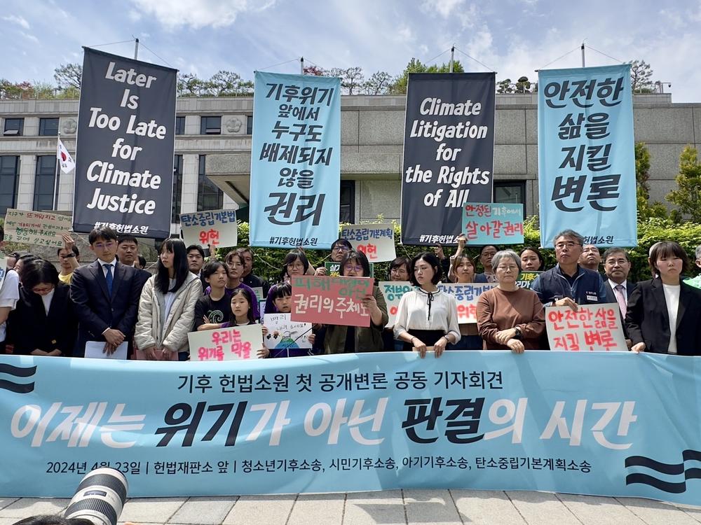 Plaintiffs, lawyers and activists gather outside South Korea's constitutional court in Seoul ahead of a public hearing for a climate lawsuit on Tuesday, April 23, 2024.