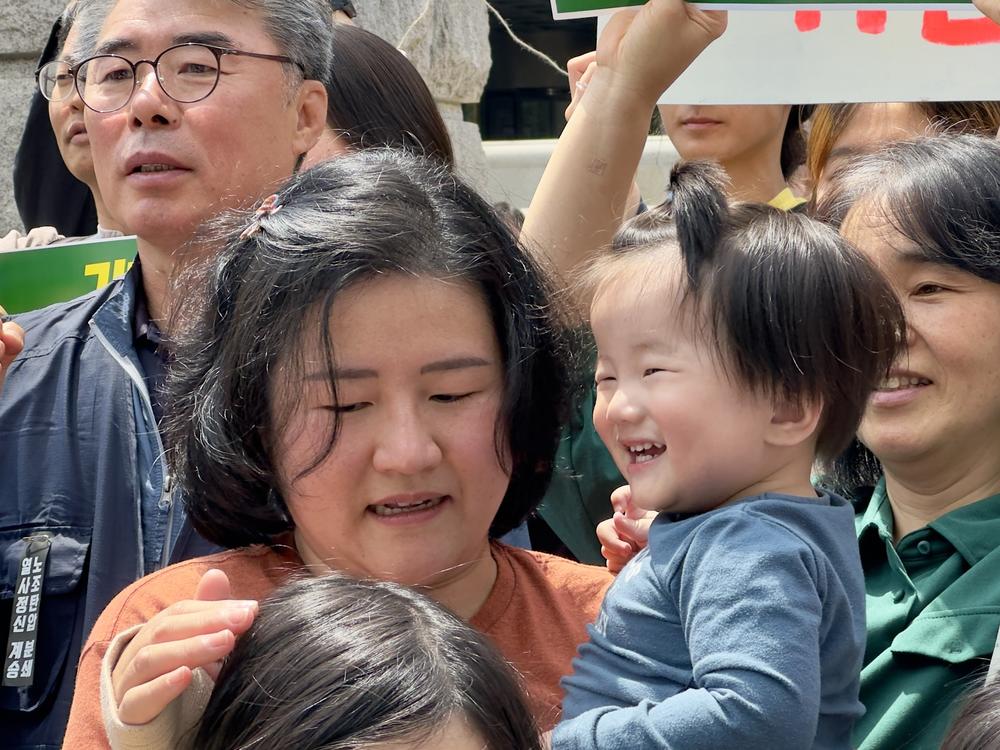 17-month-old Choi Heewoo nicknamed Woodpecker, held by his mother, is the youngest plaintiff in a landmark climate litigation case