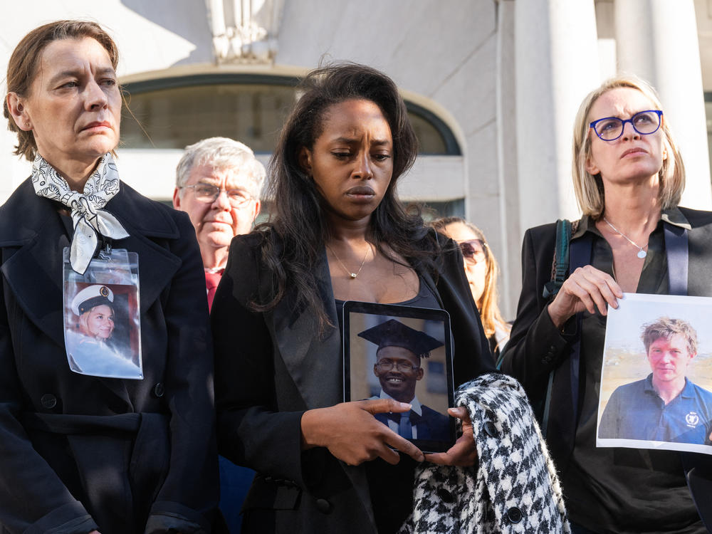 Catherine Berthet (left), Zipporah Kuria (center) and Naoise Connolly Ryan (right) hold photos of relatives who were killed in the crash of Ethiopian Airlines Flight 302 in 2019.