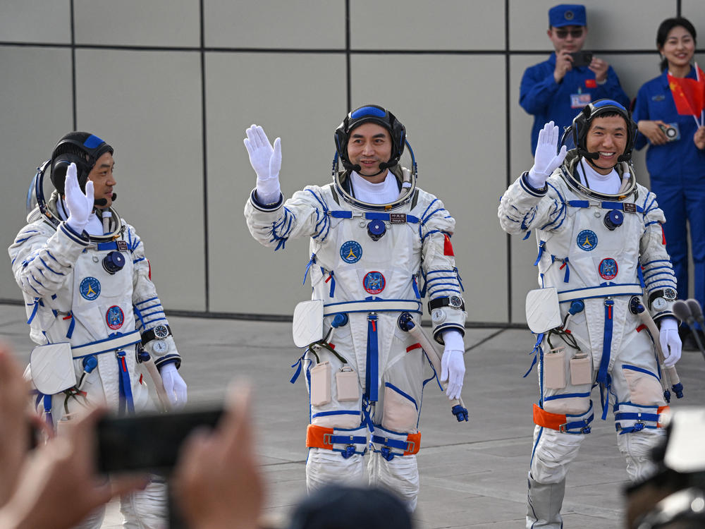 From left, astronauts for China's Shenzhou-18 space mission Li Guangsu, Ye Guangfu and Li Cong wave during a departure ceremony before boarding a bus to take them to the Shenzhou-18 spacecraft at the Jiuquan Satellite Launch Center in the Gobi desert in northwest China on Thursday.