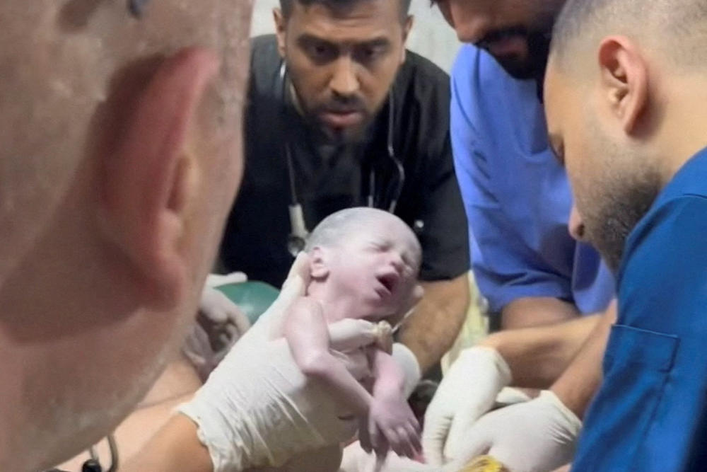 A medic holds a newborn girl after she was delivered via cesarean section at a hospital in Rafah in the southern Gaza Strip, in this still image taken from a video recorded April 20.