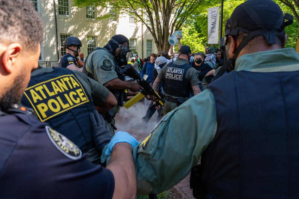 An Atlanta Police officer fires pepper pellets onto the ground as Atlanta Police Department and Georgia State Patrol order Pro-Palestinian and 