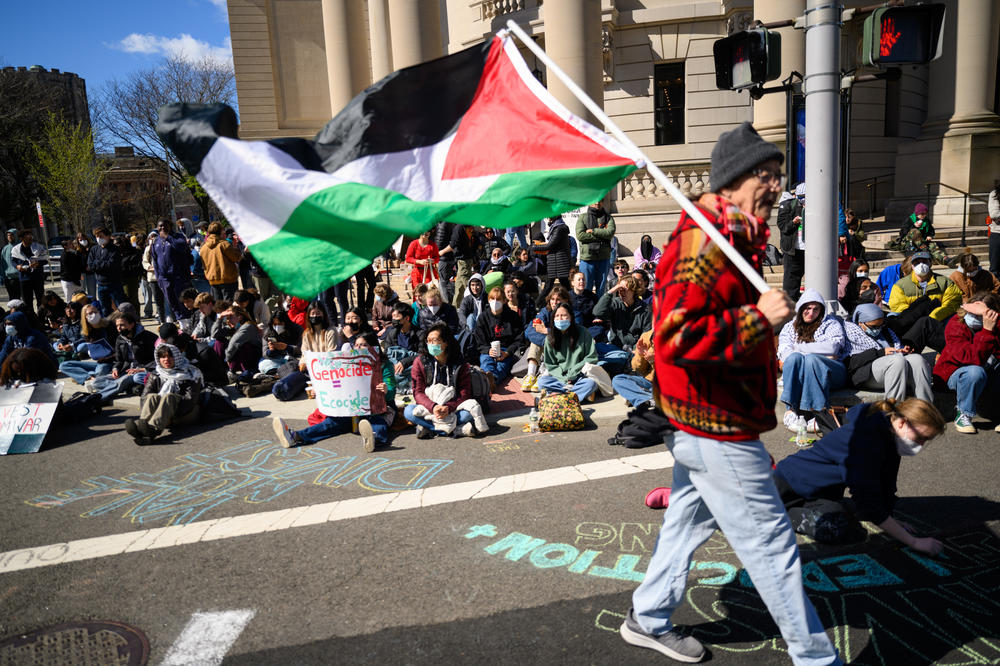 New Haven activist Norm Clement walks with a Palestinian flag in front of hundreds of Yale students, who shut down an intersection in downtown New Haven on April 22, 2024 after police cleared an encampment and arrested 45 students outside the Beinecke library.