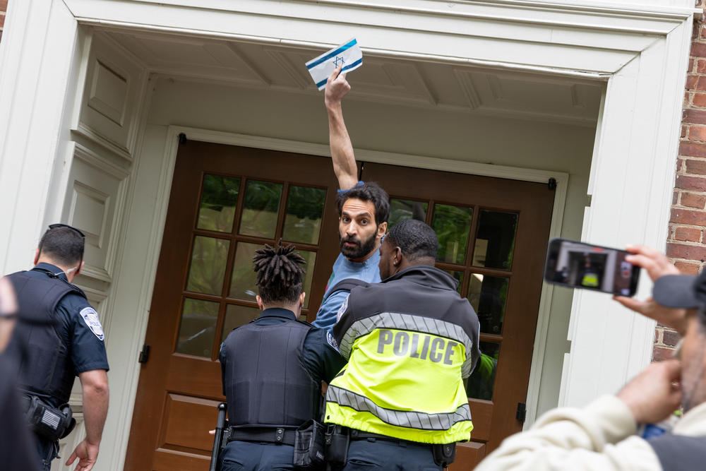 Pro-Palestinian demonstrators occupy the University Yard of The George Washington University in downtown Washington, D.C. on Thursday. A person with an Israeli flag argued with the group of Pro-Palestinian demonstrators and had to be escorted away and into a university building by GWU police.