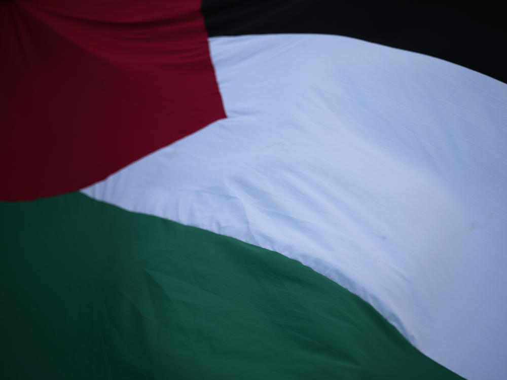 People flutter a Palestinian flag in Lisbon during a Dec. 8, 2023, demonstration in support of the Palestinian people and demanding a cease-fire in Gaza.