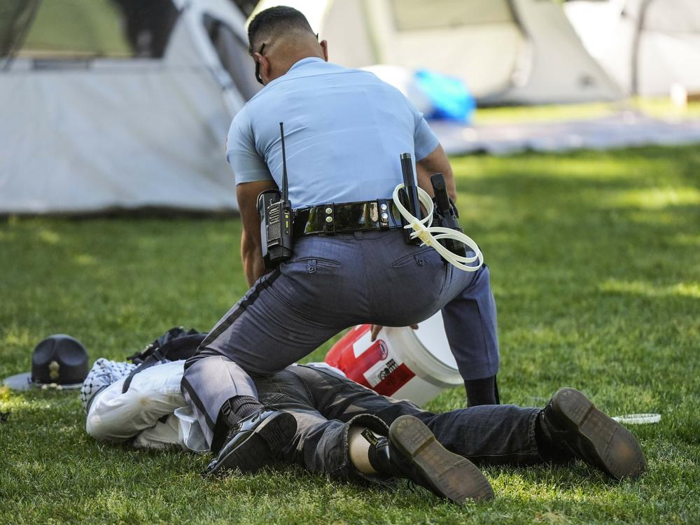 A Georgia State Patrol officer detains a protester on the campus of Emory University during a pro-Palestinian demonstration Thursday in Atlanta.
