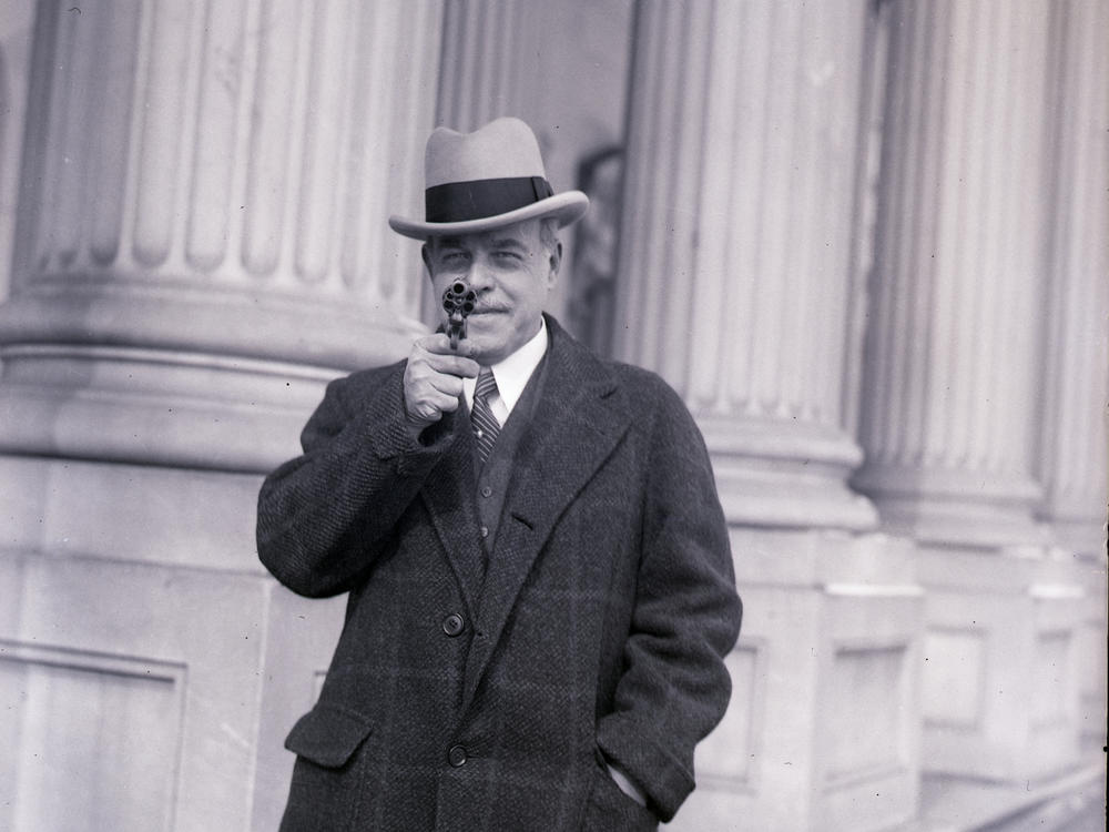 Nicholas Longworth, speaker of the House, holds a gun once owned by famous outlaw Jesse James on Jan. 23, 1930.