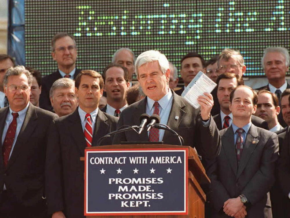 House Speaker Newt Gingrich (center), shown here surrounded by House Republicans, holds up a copy of the 