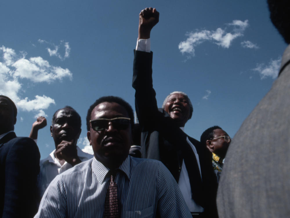 Bodyguards keep close watch as Nelson Mandela celebrates his victory in the South African presidential elections of 1994. As the head of the African National Congress, he helped to build the country's new multiracial government and to establish the free elections in which he won his presidency.