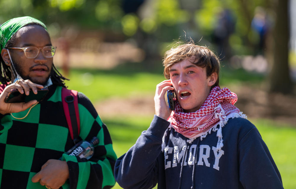 A protester talks on the phone after being exposed to pepper spray and tear gas on the campus of Emory University on Thursday, April 25, 2024.