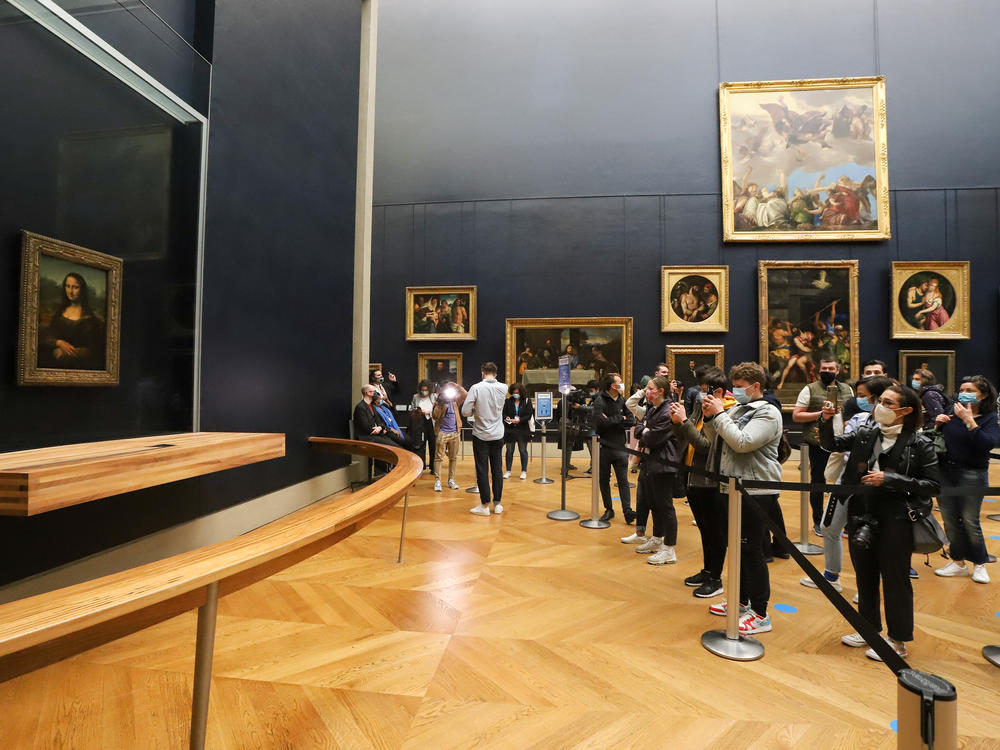 A visitor photographs the painting the <em>Mona Lisa</em> by Italian artist Leonardo Da Vinci on display in a gallery at the Louvre on May 19, 2021 in Paris.