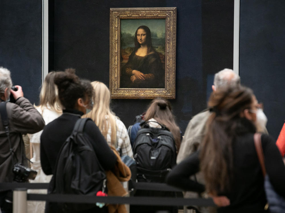 Visitors observe the painting the <em>Mona Lisa</em> by Italian artist Leonardo da Vinci on display in a gallery at Louvre on May 19, 2021 in Paris, France.
