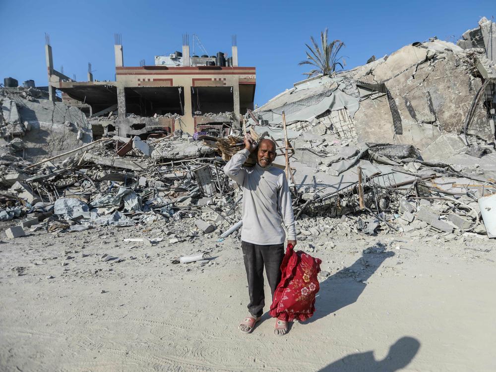 People inspect damage and remove items from their homes following Israeli airstrikes on April 7, in Khan Yunis, Gaza.