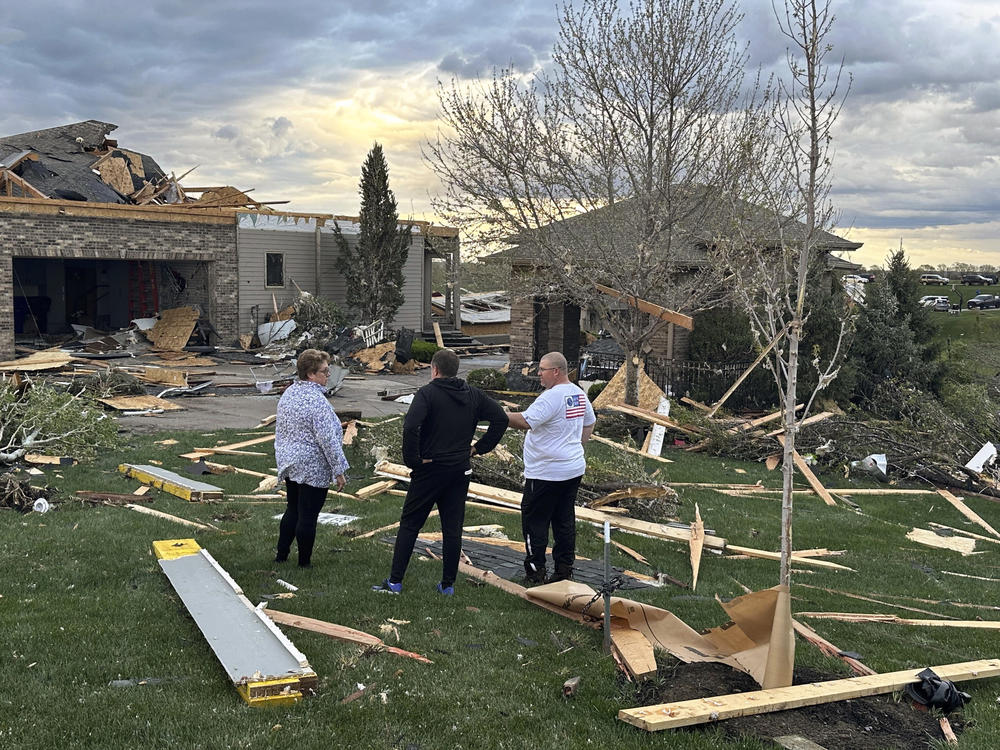 Homeowners in Bennington, Neb., assess the damage after a tornado passed through their neighborhood northwest of Omaha on Friday.