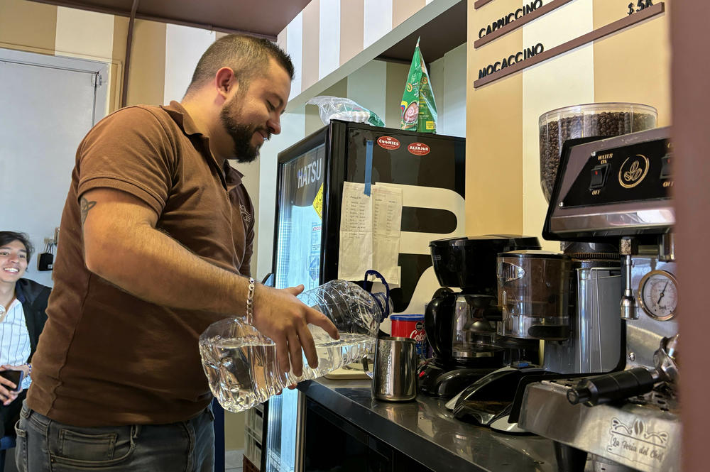 Steven Ramos makes filtered coffee using bottled water on Wednesday April 24. Ramos runs a small coffee shop in Bogotá, but he cannot use his espresso machine when water is cut off in his neighborhood.