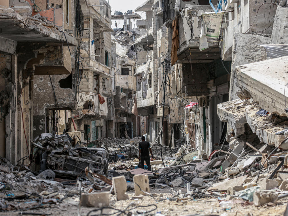 A Palestinian man walks on building rubble in Khan Yunis in the southern Gaza Strip on April 22.