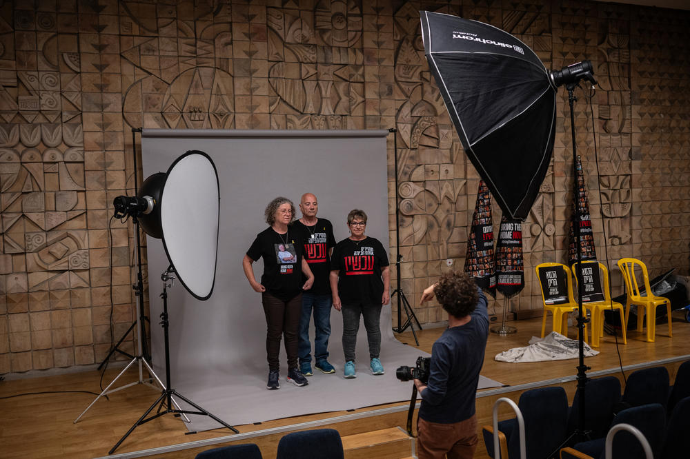 Aviva Siegel stands with Luis Har and his partner Clara Marman, both of whom were also abducted on Oct. 7, during a photo session for an Israeli news outlet in Tel Aviv, on March 28. 
