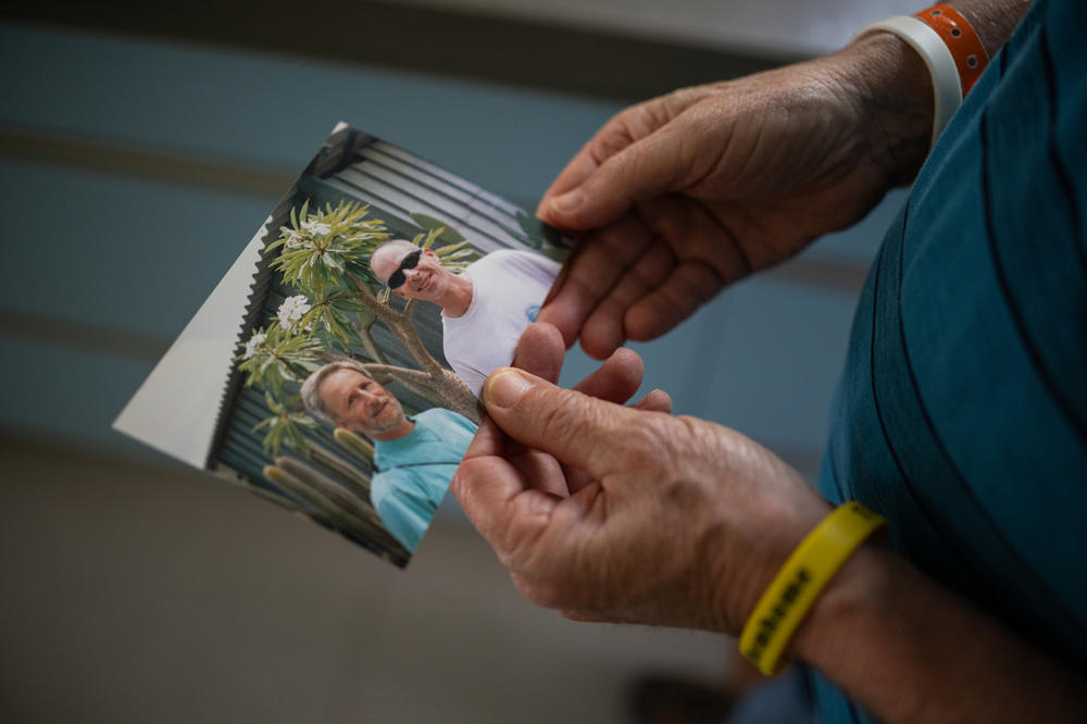 At his home on Kibbutz Gezer, Lee Siegel looks at a photo of himself together with his younger brother Keith, who is still being held hostage in Gaza, on March 30. Lee describes his brother as an 
