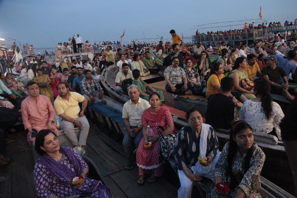 Worshippers and tourists sit on boats facing the bank of the Ganges River in the holy Hindu city of Varanasi to watch the Ganga Aarti, a ritual of devotion to the venerated river.