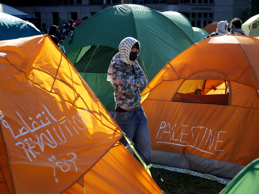 A person stands among tents at an encampment set up by pro-Palestinian protesters on the campus of Columbia University on April 25, 2024.
