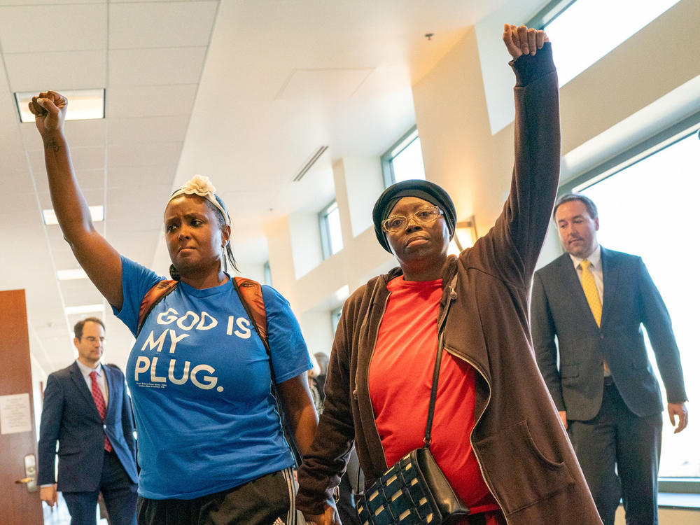After suspended Aurora Police Officer Nathan Woodyard was found not guilty on charges over his role in the death of Elijah McClain, his mother Sheneen McClain, right, and supporter MiDian Holmes joined hands and raised their fists in protest as they left a courtroom at the Adams County Justice Center, Nov. 6, 2023.