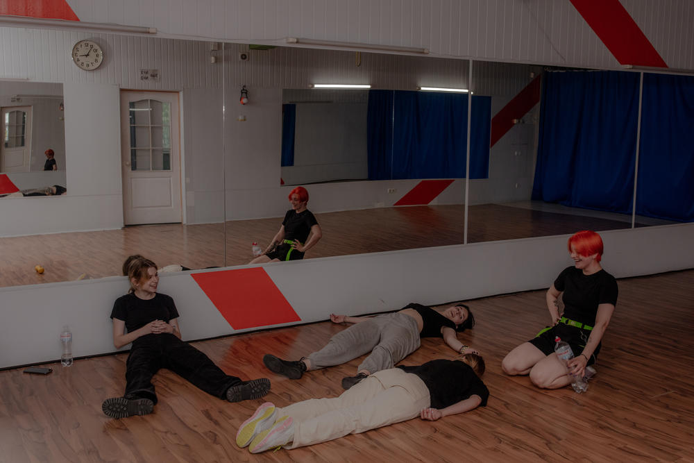 Members of the Phantom Blue dance squad take a break resting on the floor after rehearsal.