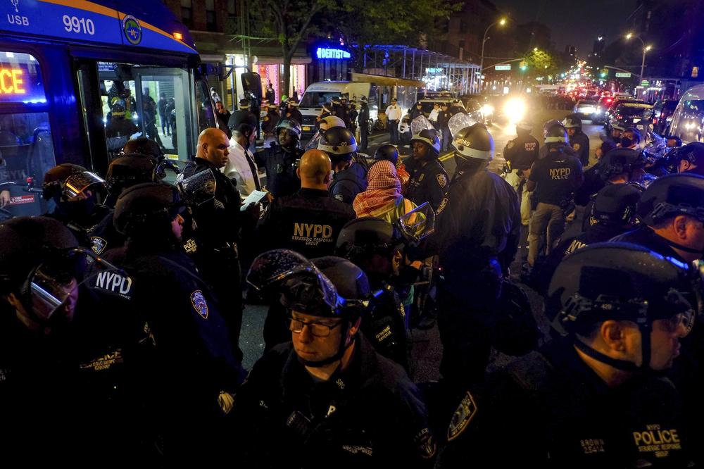 New York Police escort protesters onto a bus after making arrests during a standoff between police and demonstrators outside the City College of New York, Wednesday.