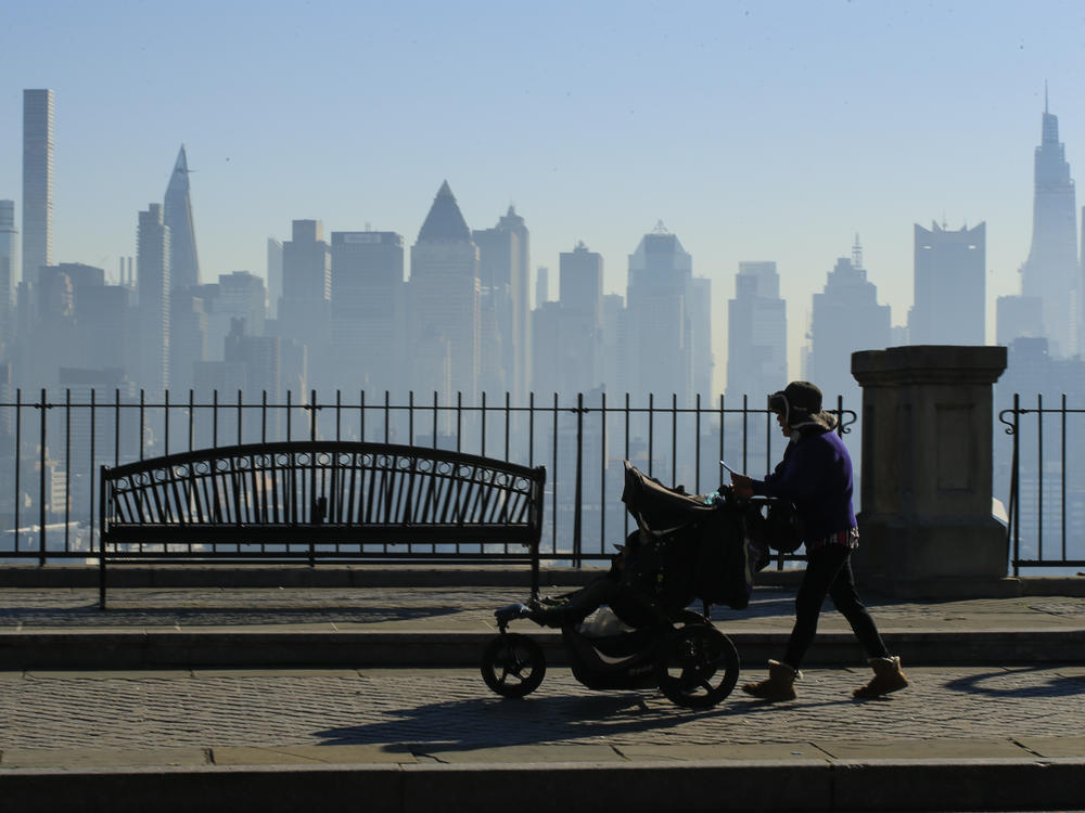 Amazon and Target are among the latest big retailers to stop selling weighted infant sleepwear due to concerns about safety. Here, a woman pushes a stroller as the New York skyline is seen from Weehawken, New Jersey.