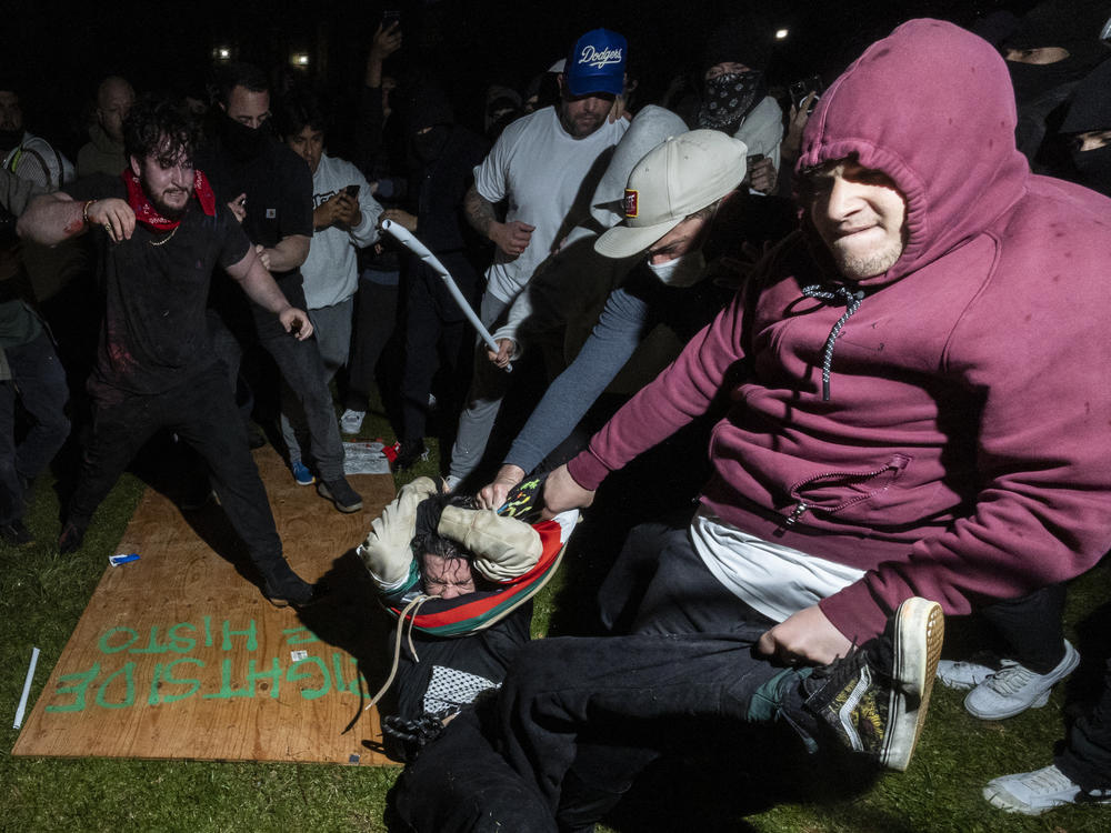 A pro-Palestinian demonstrator, center, is beaten by counterprotesters during violence on the UCLA campus early Wednesday.