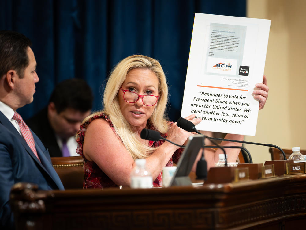 Rep. Marjorie Taylor Greene, R-Ga., holds a sign showing a screenshot of the viral flyer as Secretary of Homeland Security Alejandro Mayorkas testifies before the House Homeland Security Committee on April 16.