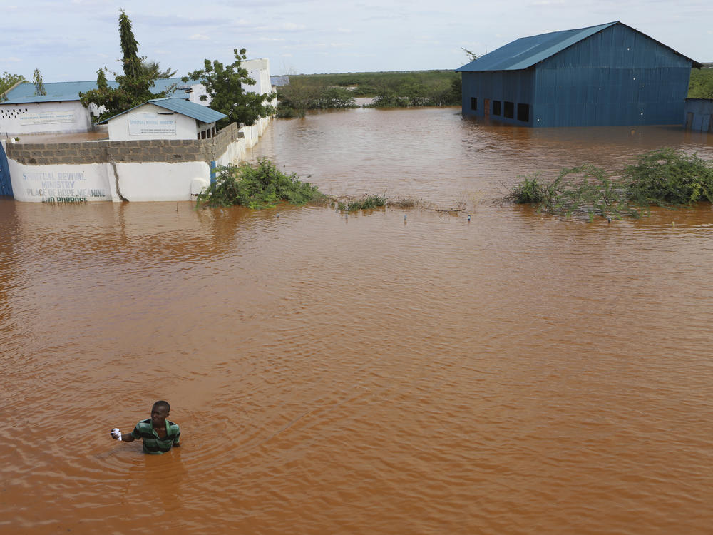 A man swims from a submerged church compound, after the River Tana broke its banks following heavy rains at Mororo, border of Tana River and Garissa counties, northeastern Kenya, April 28. Heavy rains pounding different parts of Kenya have led to dozens of deaths and the displacement of tens of thousands of people, according to the United Nations.