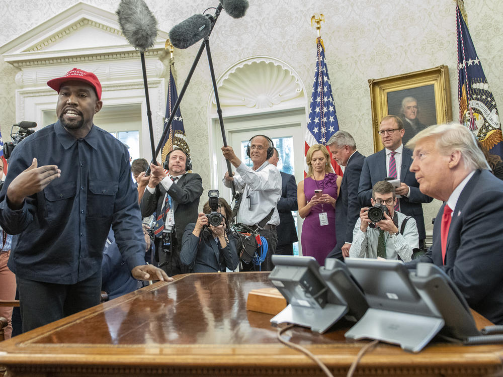 A crowd of White House press looks on as Kanye West and then-President Donald Trump meet in the Oval Office on Oct. 11, 2018.