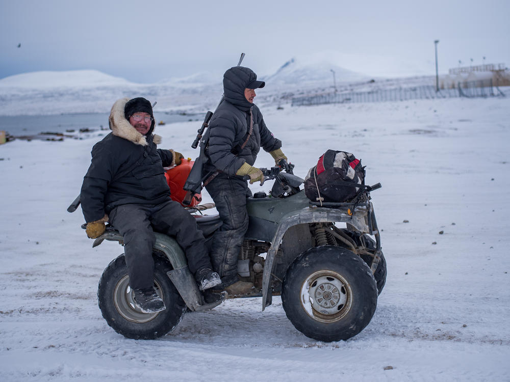 Joanasie Illauq, left, catches a ride home from the Clyde River harbor after hunting for narwhal in October 2016. He is part of Canada's Inuit community, whose members are permitted to hunt the marine mammals.
