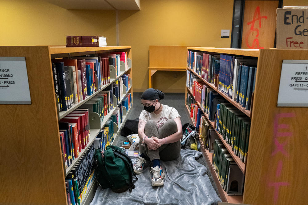 A person prepares to rest for the evening in the library, inside the occupied Branford Price Millar Library at Portland State University on April 30. All books were shelved and no books were seen damaged or disturbed.