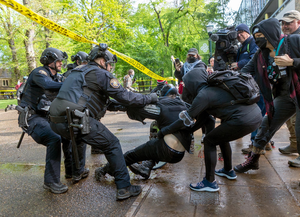 A person who attempted to escape from the library is detained and arrested. Law enforcement teams clear protesters from Portland State University's Branford Price Millar Library on May 2. Demonstrators protesting the war in Gaza have occupied the library since Monday evening.