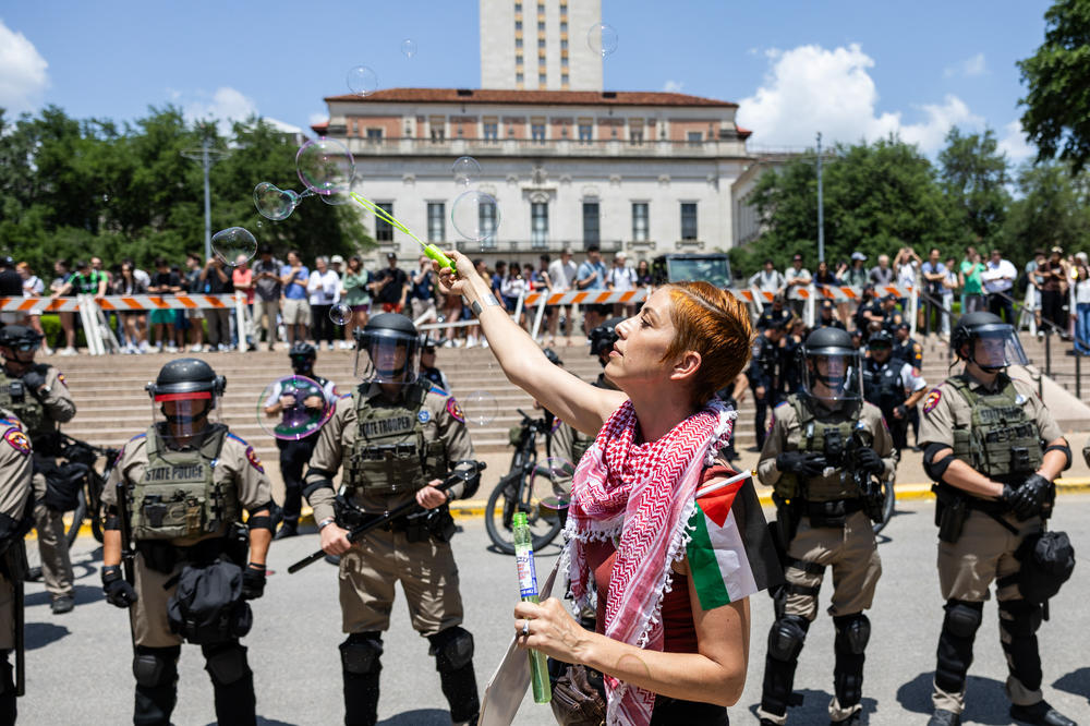 A pro-Palestinian protestor blows bubbles in front of a line of Texas State Troopers on April 29, at the University of Texas at Austin.