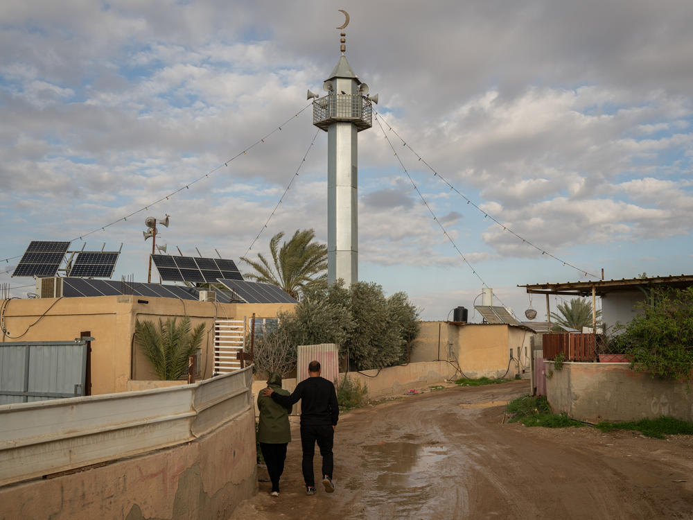 Mohammad Abu Queider and his wife Mayada walk through al-Zarnuq.