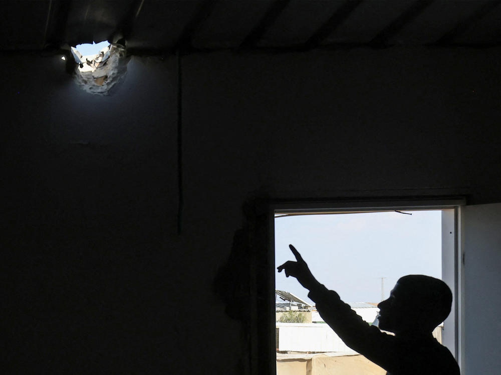 A relative points to a hole in the roof of Mohammed al-Hassouni's family home. It was caused by an Iranian missile fragment that injured his 7-year-old daughter on the night Iran attacked Israel.