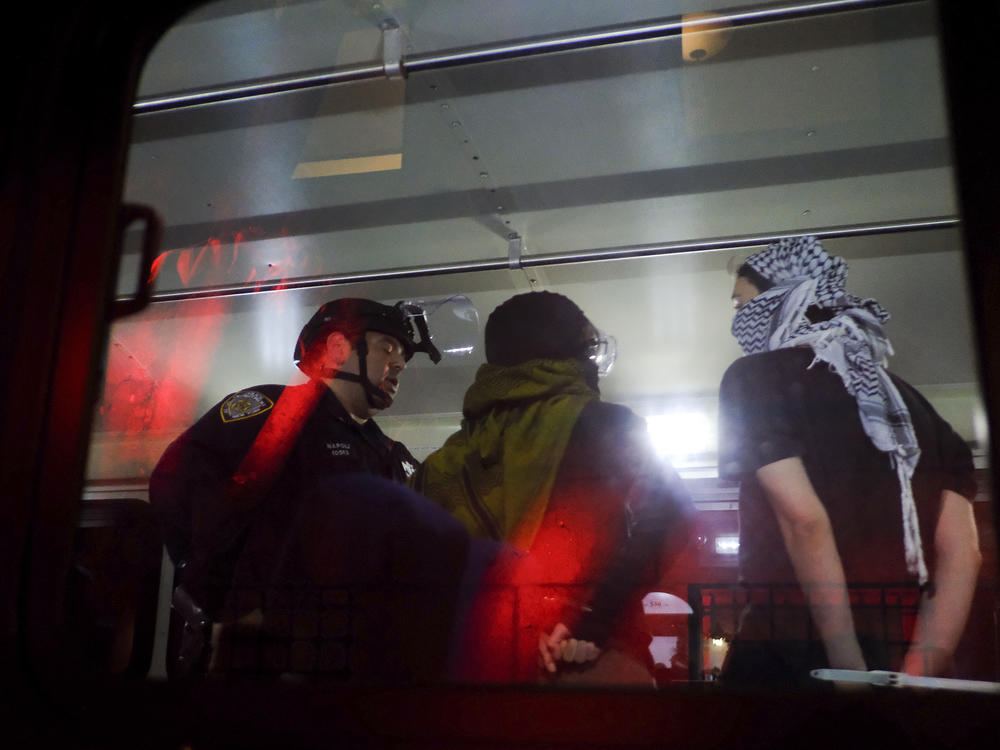 New York Police Department officers load arrested protesters from Columbia University onto a bus, on Tuesday in New York.