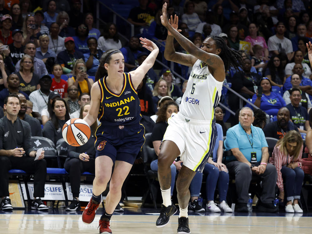Indiana Fever guard Caitlin Clark (22) drives past Dallas Wings forward Natasha Howard (6) during their WNBA basketball game in Arlington, Texas, on Friday.