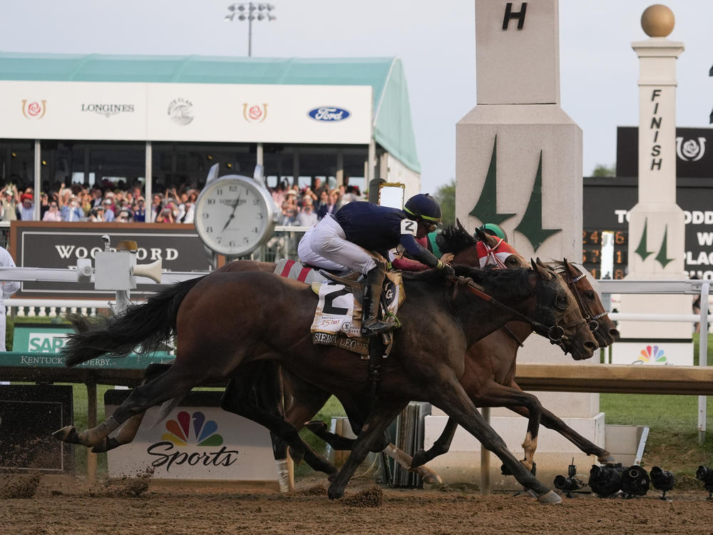 Sierra Leone, with jockey Tyler Gaffalione, (2), Forever Young, with jockey Ryusei Sakai, and Mystik Dan, with jockey Brian Hernandez Jr., cross the finish line at Churchill Downs during the 150th running of the Kentucky Derby horse race Saturday, in Louisville, Ky.
