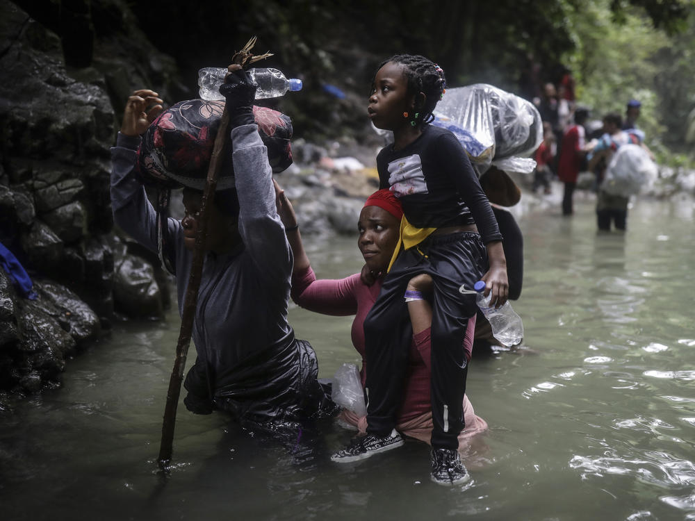 Haitian migrants wade through water as they cross the Darien Gap from Colombia to Panama on May 9, 2023.