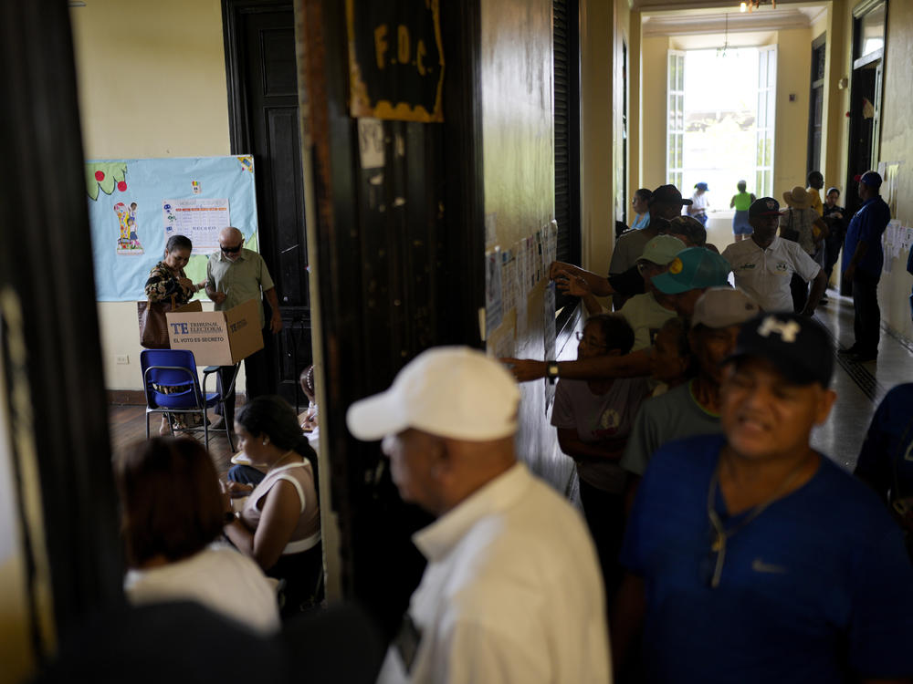 A man votes assisted by a woman during a general election in Panama City, on Sunday.