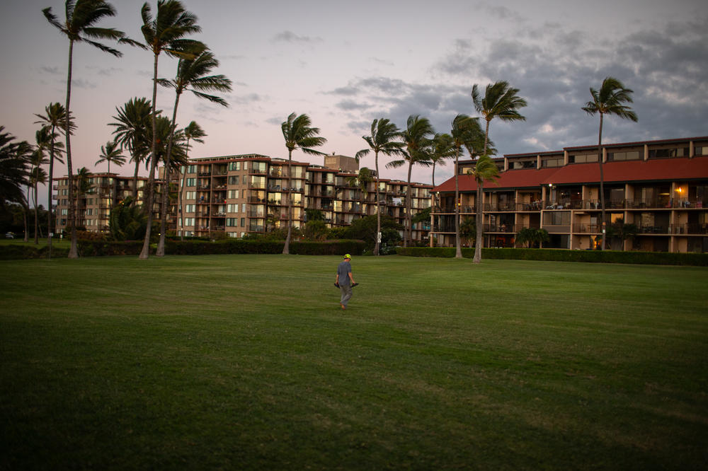 A beachgoer returns inland after watching the sunset. In Hawaii, many have a deep connection to the ocean through their livelihoods or daily lives.