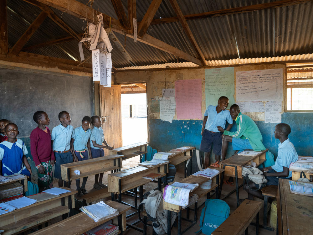 Saidimu, Loshaki and Paris look on as their much younger third-grade classmates sing a song.