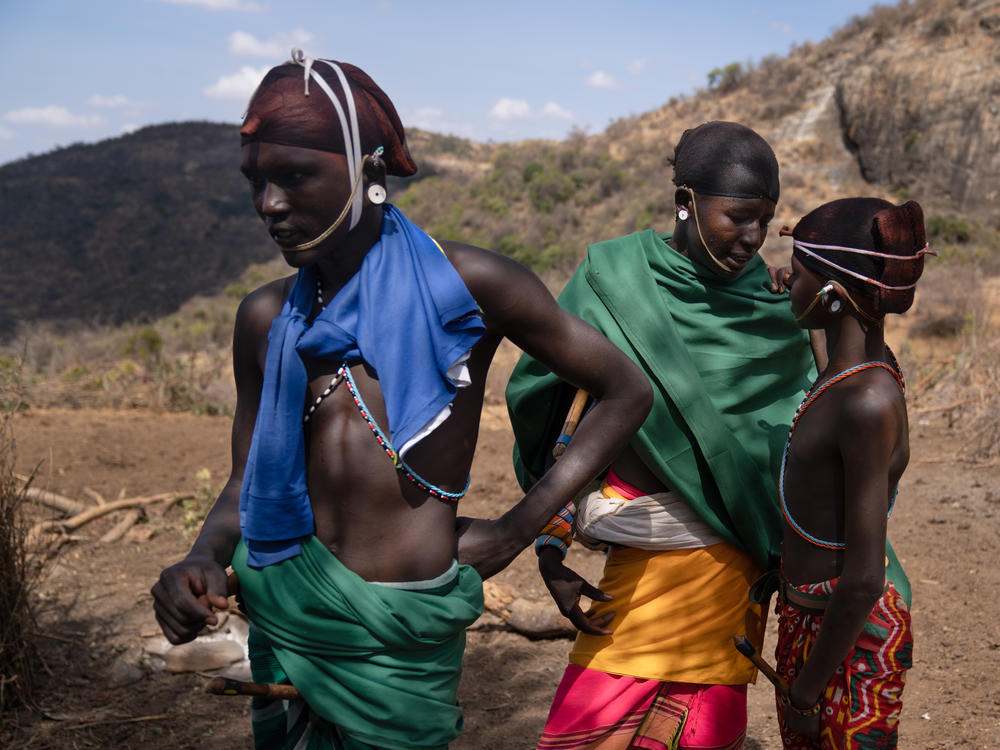 Three morans hang out at their campsite: Ltesekwa (center), Leseu Mareketo (left) and Lepenari Lepeni. The beaded ornaments they wear mark them as morans.