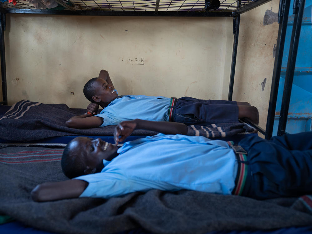 Paris (front) and Saidimu relax on their beds at the dormitory.