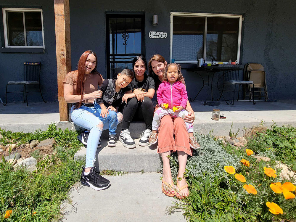 Hengarlyth Jimenez (from left) and her son, Alan, Neydira López and her daughter, Fabiola, and Mountain View Mayor Emilie Mitcham sit in front of Mitcham's duplex, which she's opened to the mothers as they pursue their own futures in Colorado, on May 4.